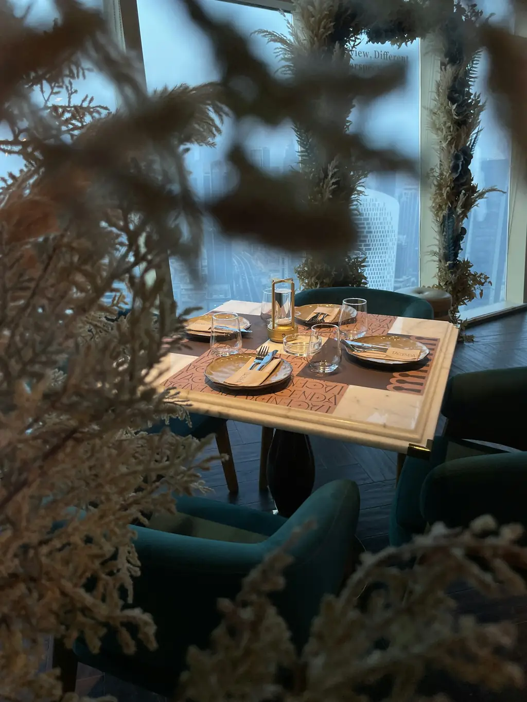 A restaurant table set for dinner beside a window